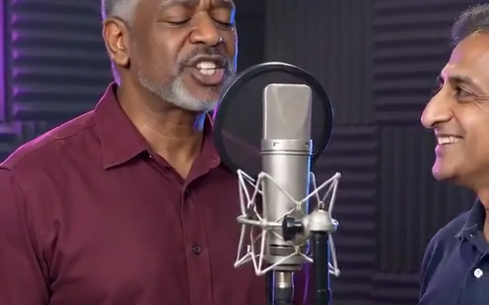 Frame from our demo: two men at a studio mic, one singing.