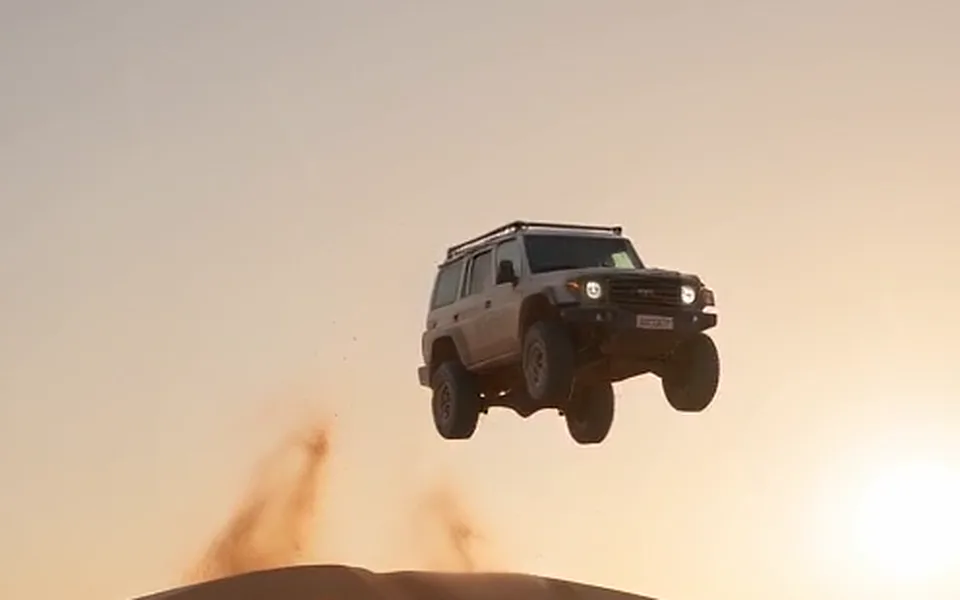 Frame from our demo: a plain off-road car with no logo, in mid-air.